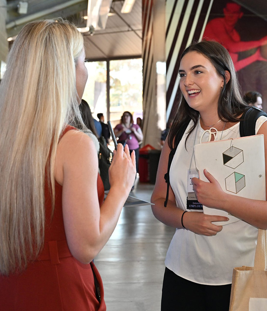 An enthusiastic student speaks with a prospective employer at the annual career expo.
