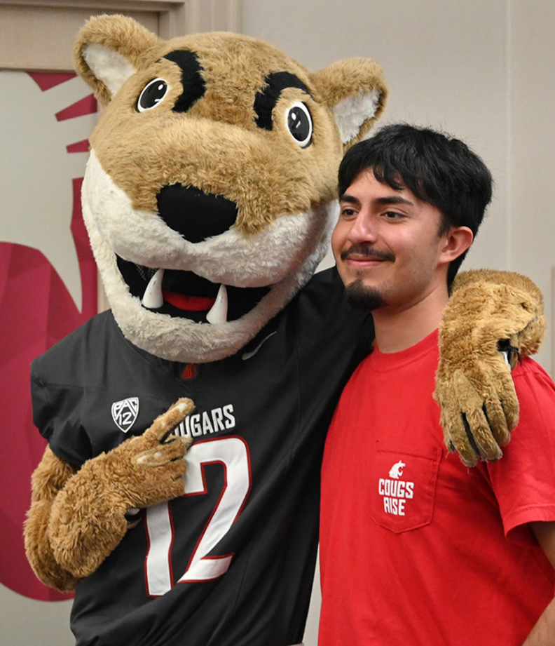 Cougs rise students take smiling pictures with WSU mascot Butch T. Cougar in The Commons Student Center.