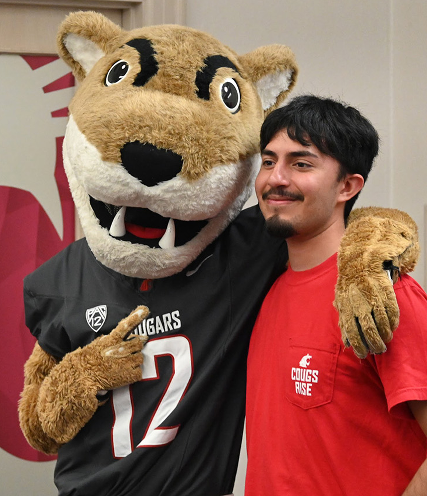 Cougs rise students take smiling pictures with WSU mascot Butch T. Cougar in The Commons Student Center.