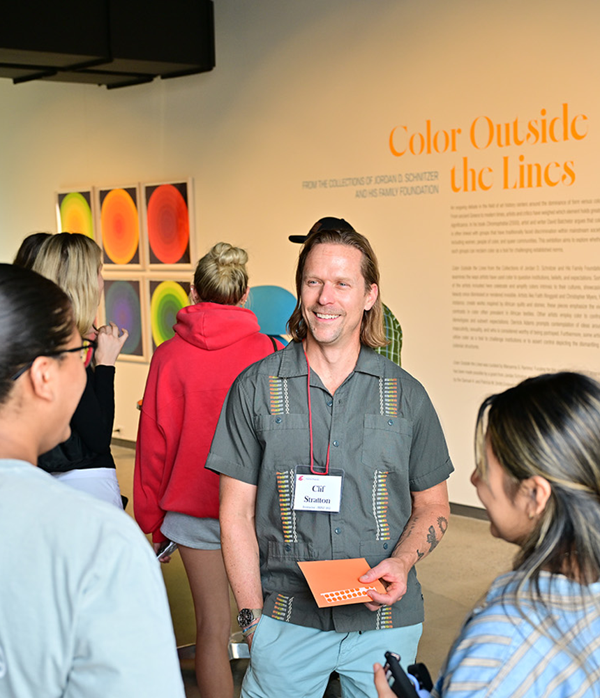 Students speak with faculty member and professor Clif Stratton in the lobby of the Jordan Schnitzer Museum of Art. They are attending the First-Year Program's Night at the Museum event.