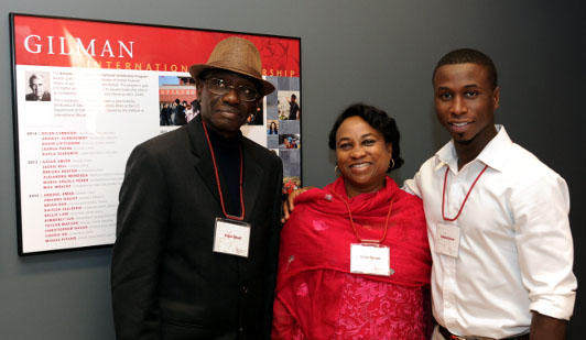 Abdul and his family pose next to the wall plaque that records his accomplishment.