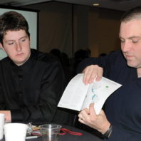 Student listening to Bryan Nyquist discuss a Peace Corps brochure