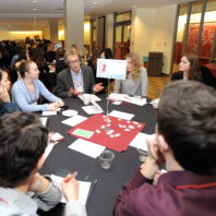 Chuck Moore talking with students sitting around his table.