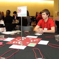 Students sitting around the table listening to Kirk Reinkens.