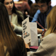 Students reading the Peace Corps brochure, "Make the Most of Your World."