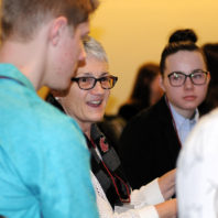 Nancy Swanger speaking with students at her table.