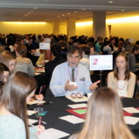 Rich Zack speaking to students at the freshman scholars progression 2018 event. The entire room full of students and speakers can be seen in the background.