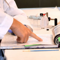 A faculty mentor points at a result in an undergraduate researcher's laboratory notebook.