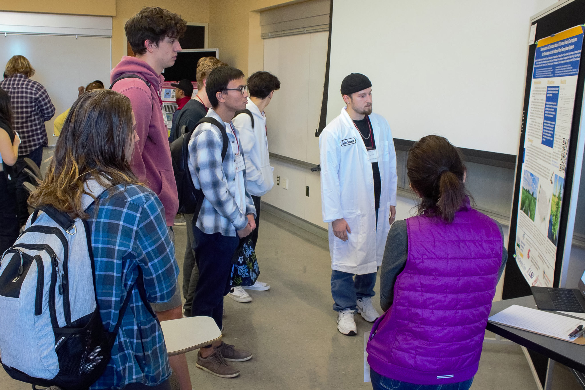 Student attendees at the STEM Research Opportunities Fair listen to a WSU lab's poster presentation during a breakout session.