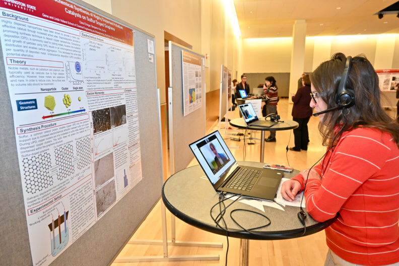 A judge listens to a virtual presentation being delivered remotely over a laptop computer at SURCA 2023.