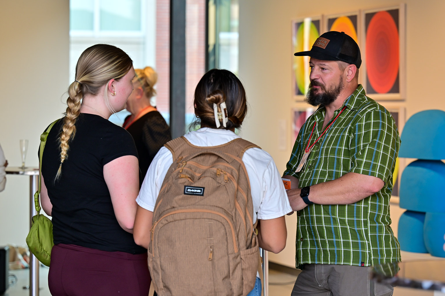 Two students speak with a professor at the “Fall 2025 First-Year Programs Evening at the Museum” event.