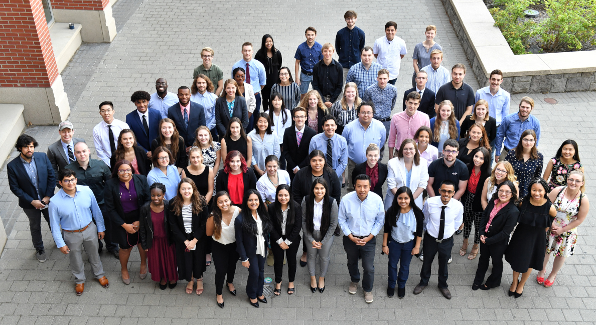 Student participants of the 2018 Summer Undergraduate Research Program stand together outside the CUE building.