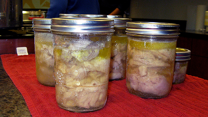 Raw packed chicken in jars after processing.