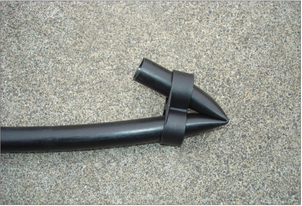 Two sided black clamp on the end of a black tube clamping it shut.