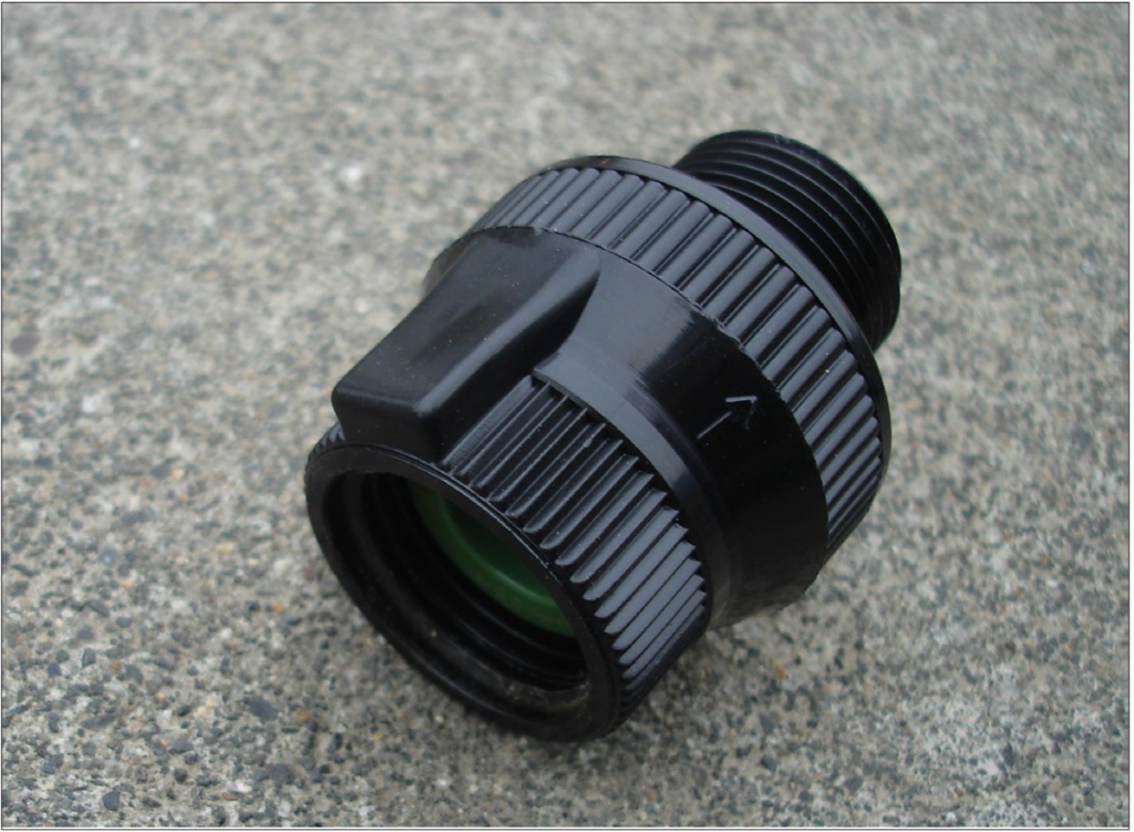 Round, black plastic backflow preventor.