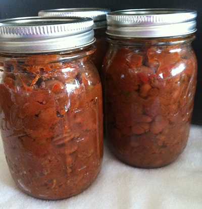 Jars of chili con carne with beans and meat, fully cooked and sealed after pressure canning.