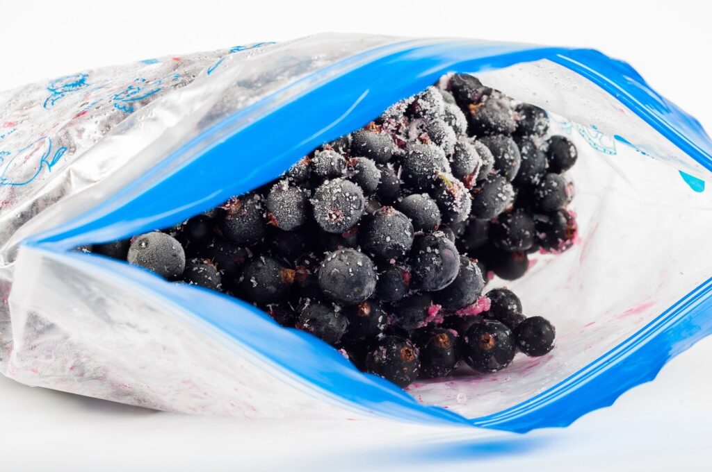 Frozen blueberries in open ziplock bag.