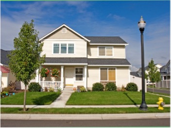 Front view of a two story house with nice landscaping on a sunny day.