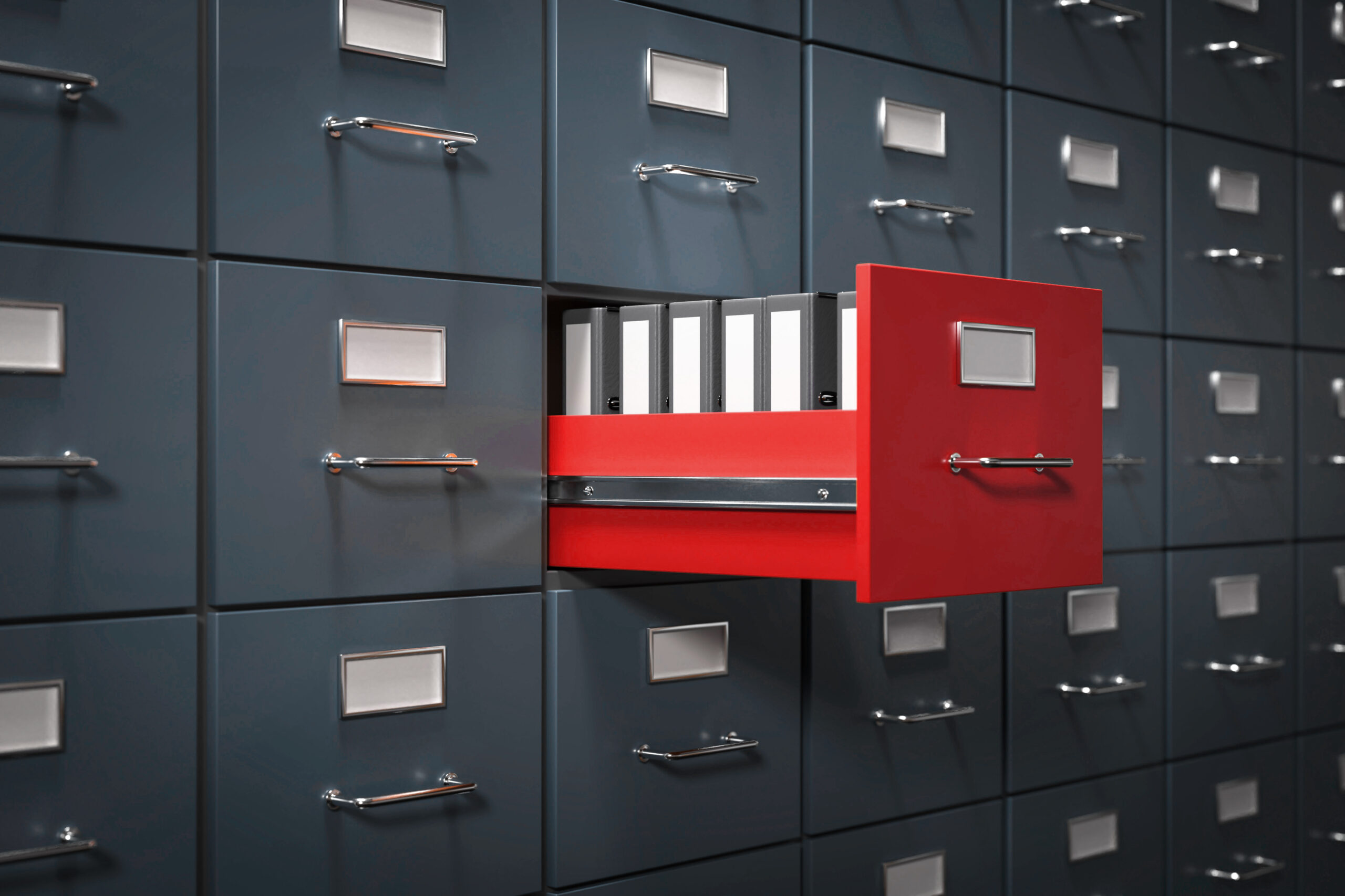 Open orange file cabinet drawer among closed blue drawers, holding binders.