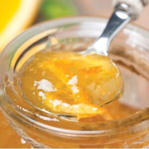 A spoon in a jar of orange marmalade