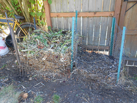 Simple two-pile system for slow composting. Fresh yard debris and vegetable scraps go into the pile on the left. The smaller pile on the right is from the previous year.