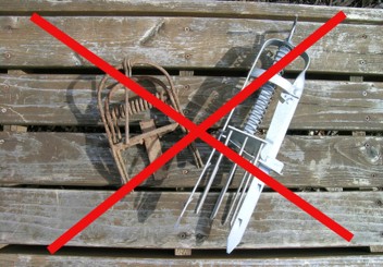 Two illegal mole traps with a large red "X" shape over them.