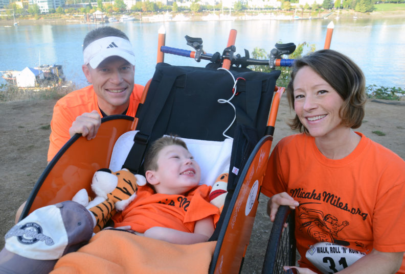 Micah in front bicycle cart next to mom and dad