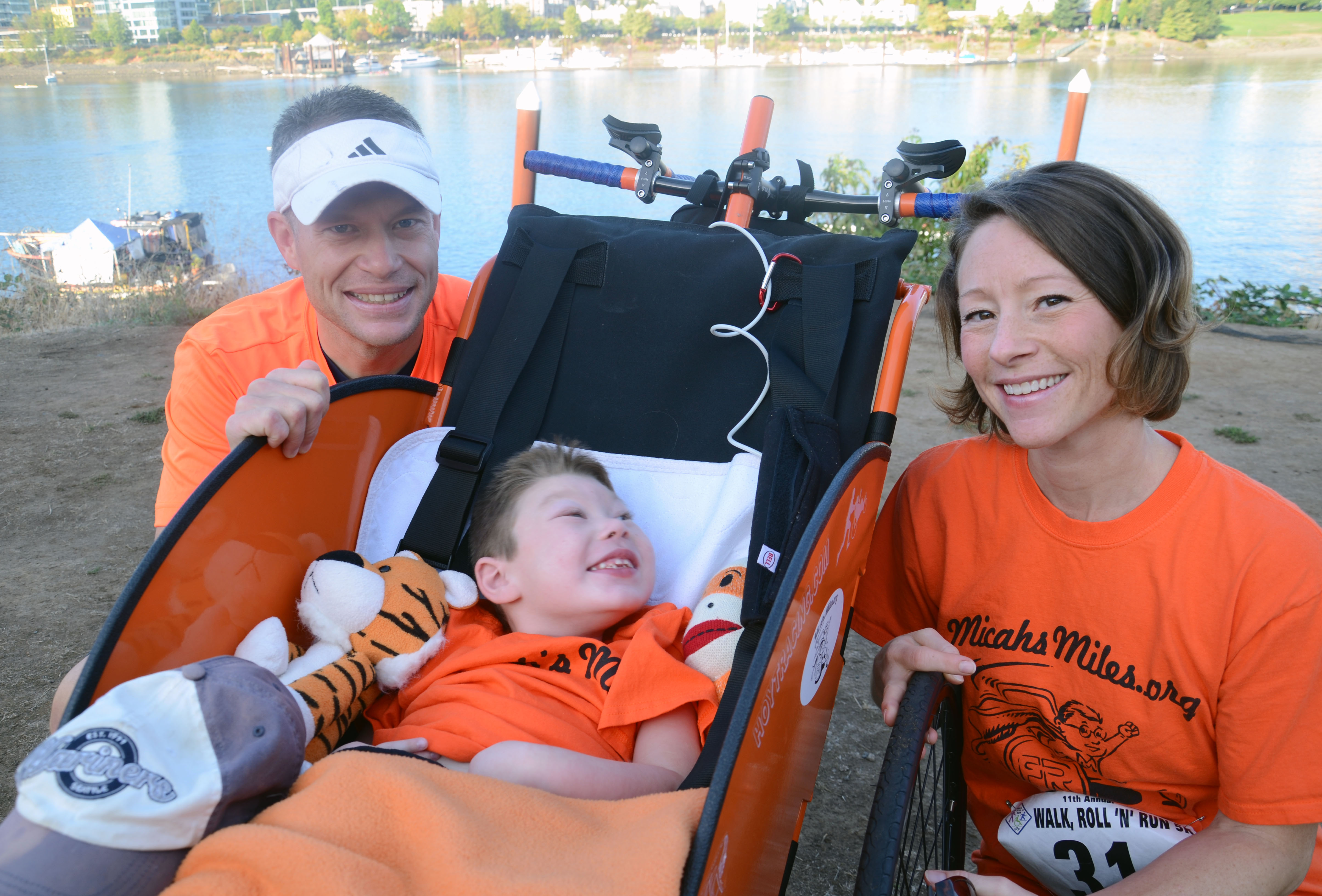 Micah in front bicycle cart next to mom and dad