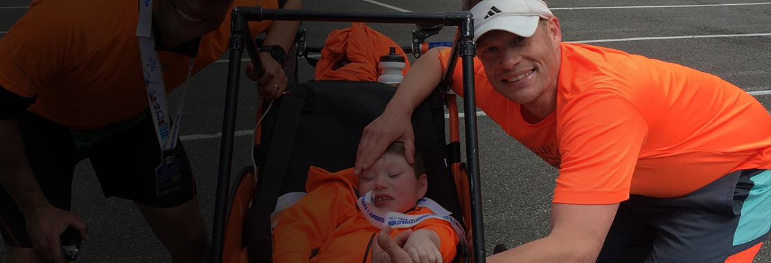 Micah in stoller flanked by dad and friend