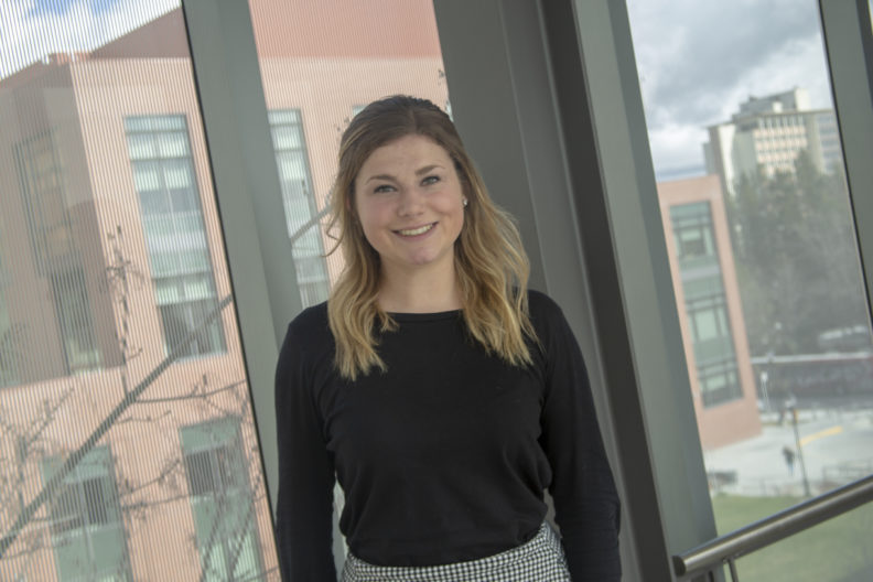 Jordan Ryan standing in front of window and smiling.