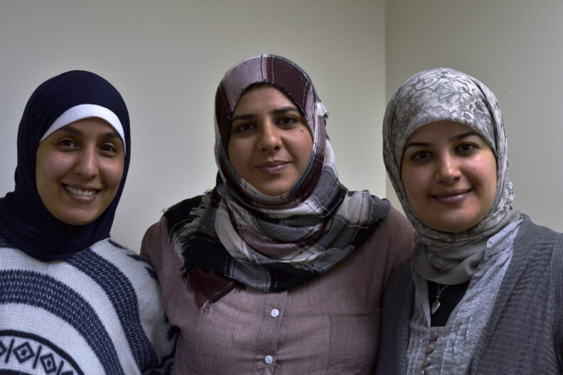 Three great friends, all from Libya, smiling at camera.