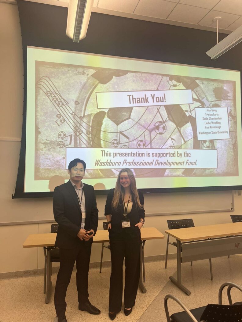 Alex Gang and Sadie Chamberlain in front of their presentation slide at the ASMA conference.