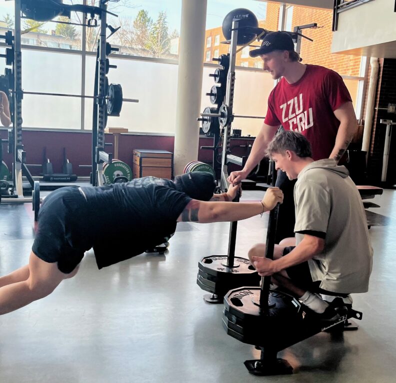 student pushing weighted sled