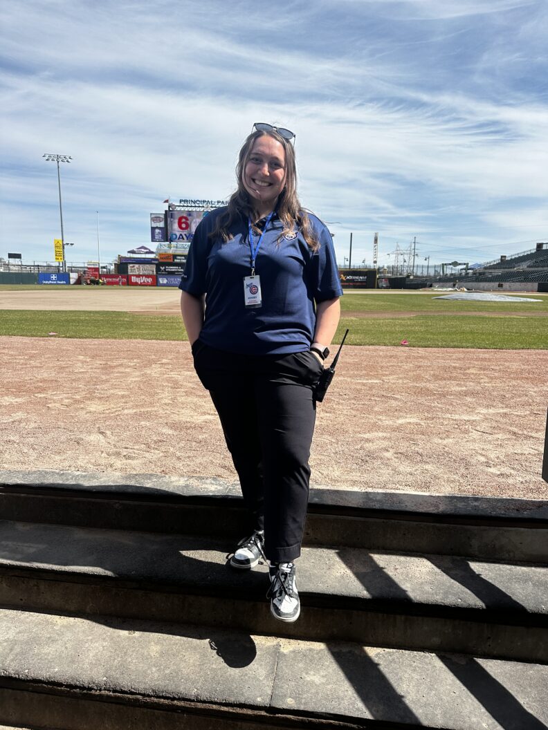 Kinsey Kallaher standing on the Iowa Cubs field.