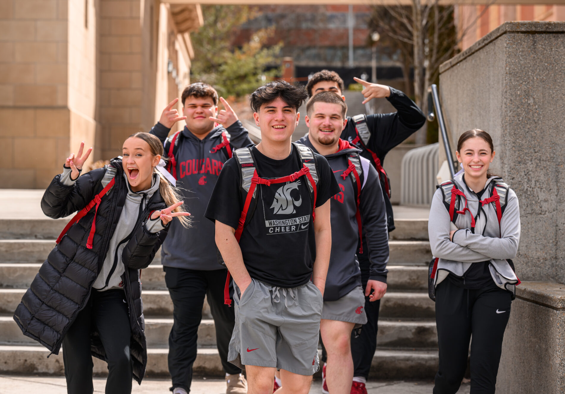 Group of students with backpacks standing together on outdoor campus steps