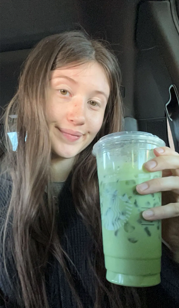 Claire smiling and enjoying her coffee