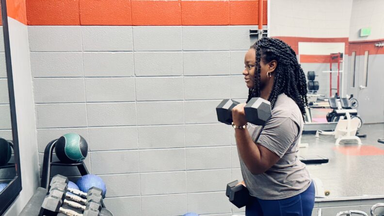 A lady holding two Weights