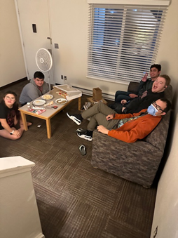 ROAR scholars sitting in a living room, eating cookies