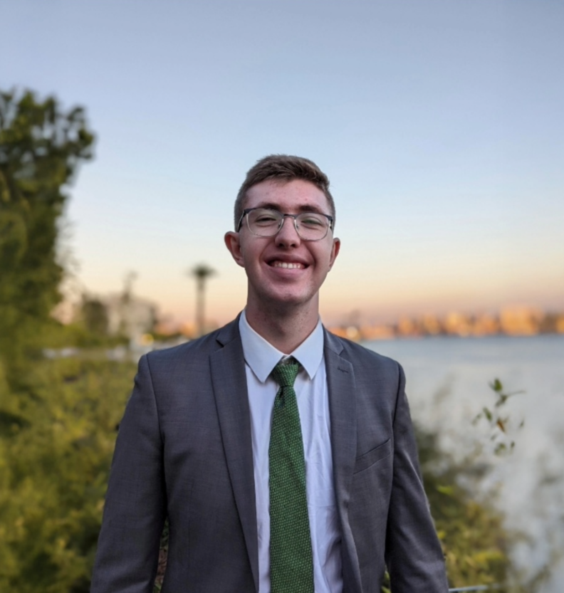 Tim Watts smiling with the ocean behind him