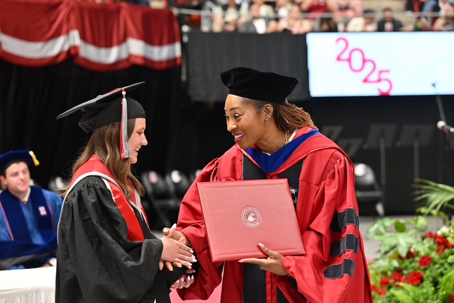 graduate and dean exchanging hand shake