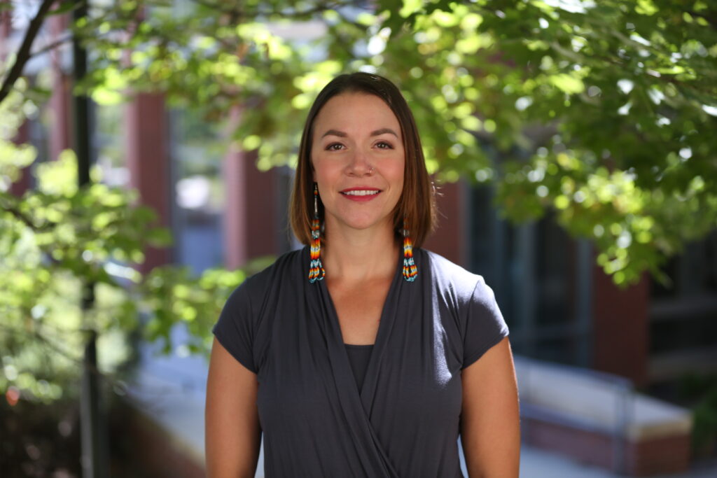 Stephany RunningHawk Johnson smiling at camera.
