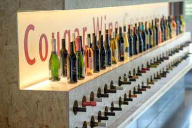 A photo with wine lined up in a row on display