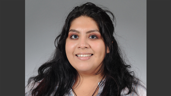 Jimena in a photo studio with the plain grey background.