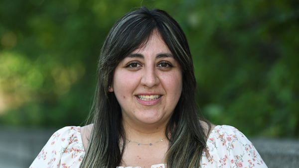 Andrea outside on a warm day. She'se wearing a flowered blouse.