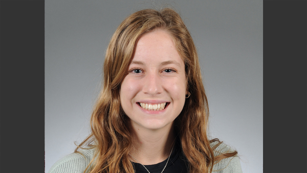 Gracie Miller in a photo studio with a grey background.