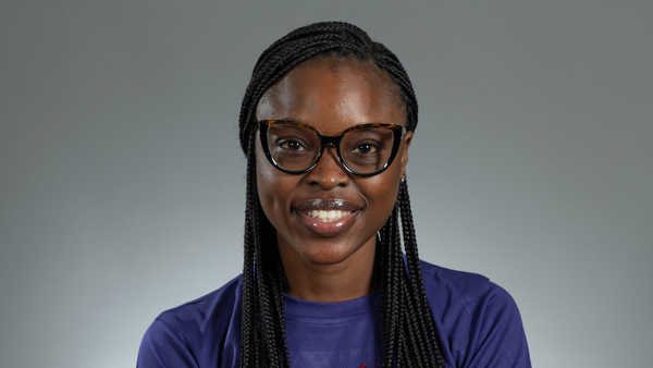 Ifeoluwa in a photo studio. She's wearing a purple top and the background is light gray.