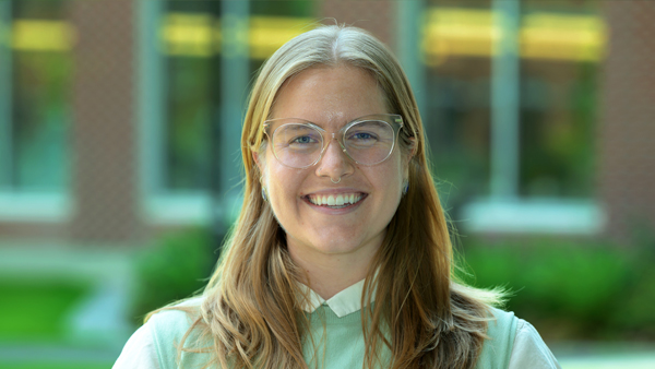 Cameron standing outside the building she works in.
