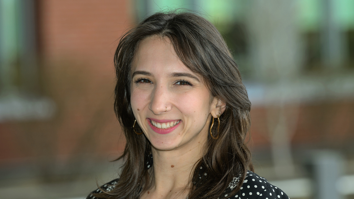 Adriana outside the college. She's wearing a black top with white polka dots.