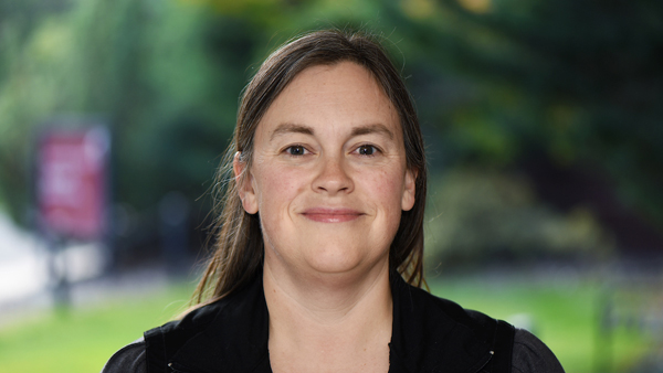 Dr. Bunch outside the Teaching Hospital. She's wearing a black top.