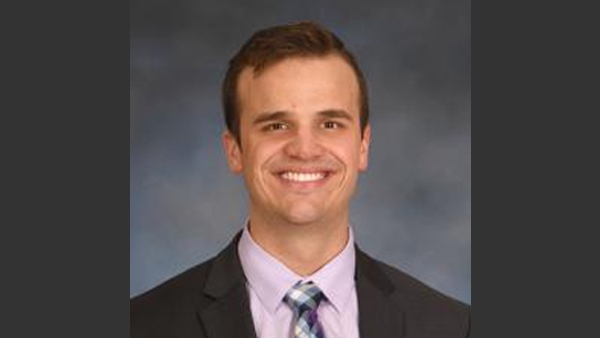 Profession headshot of Kirby. He's wearing a suit and tie.